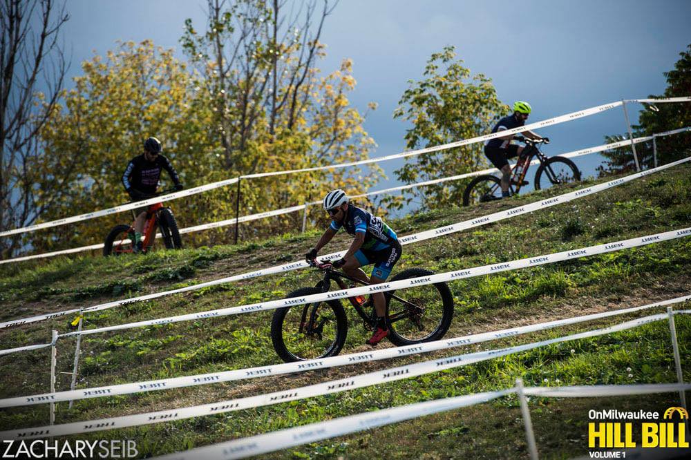 Three fat bike racers wend their way through the maze of race tape.