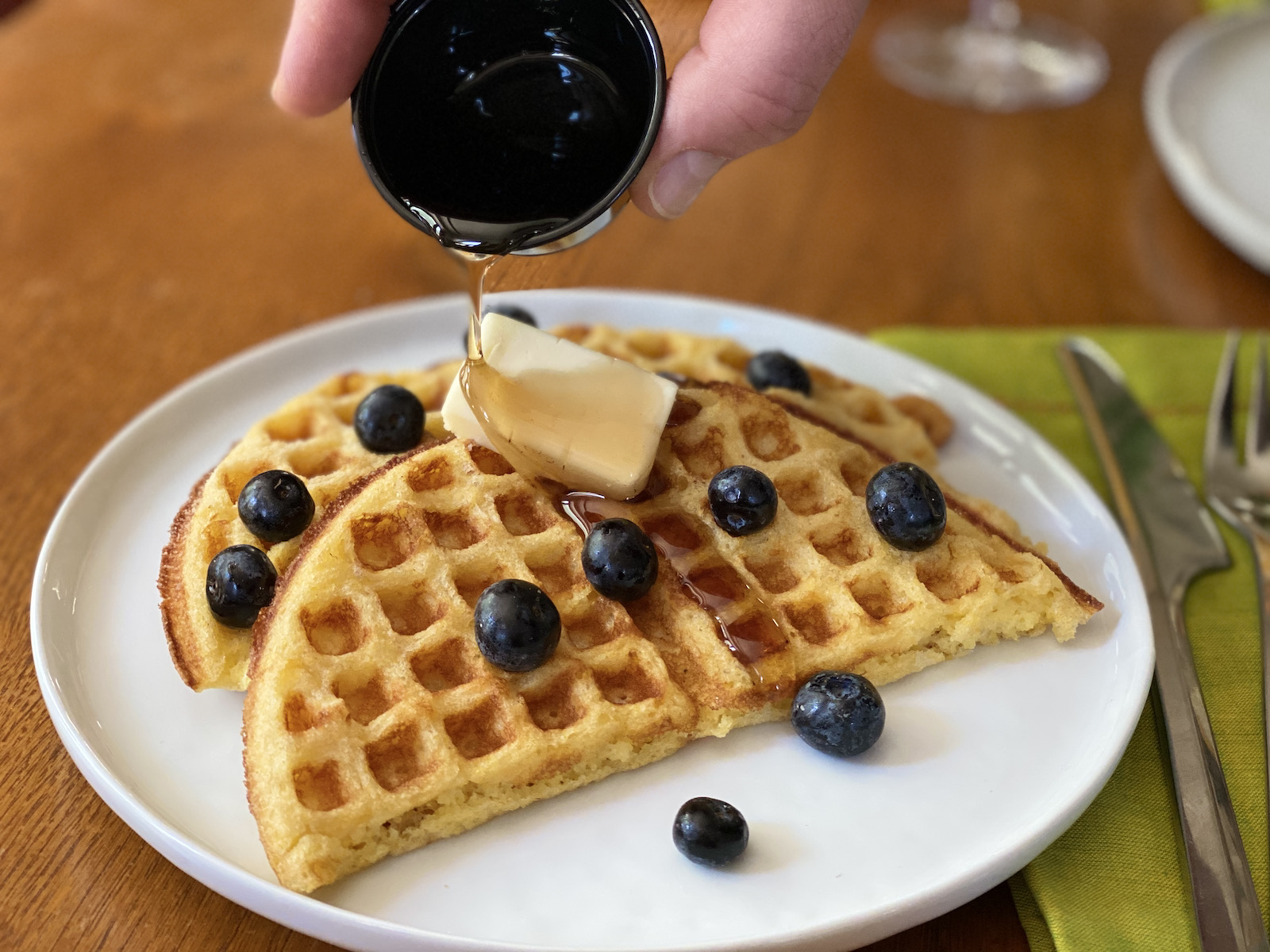 Cornmeal waffle with butter, blueberries and maple syrup