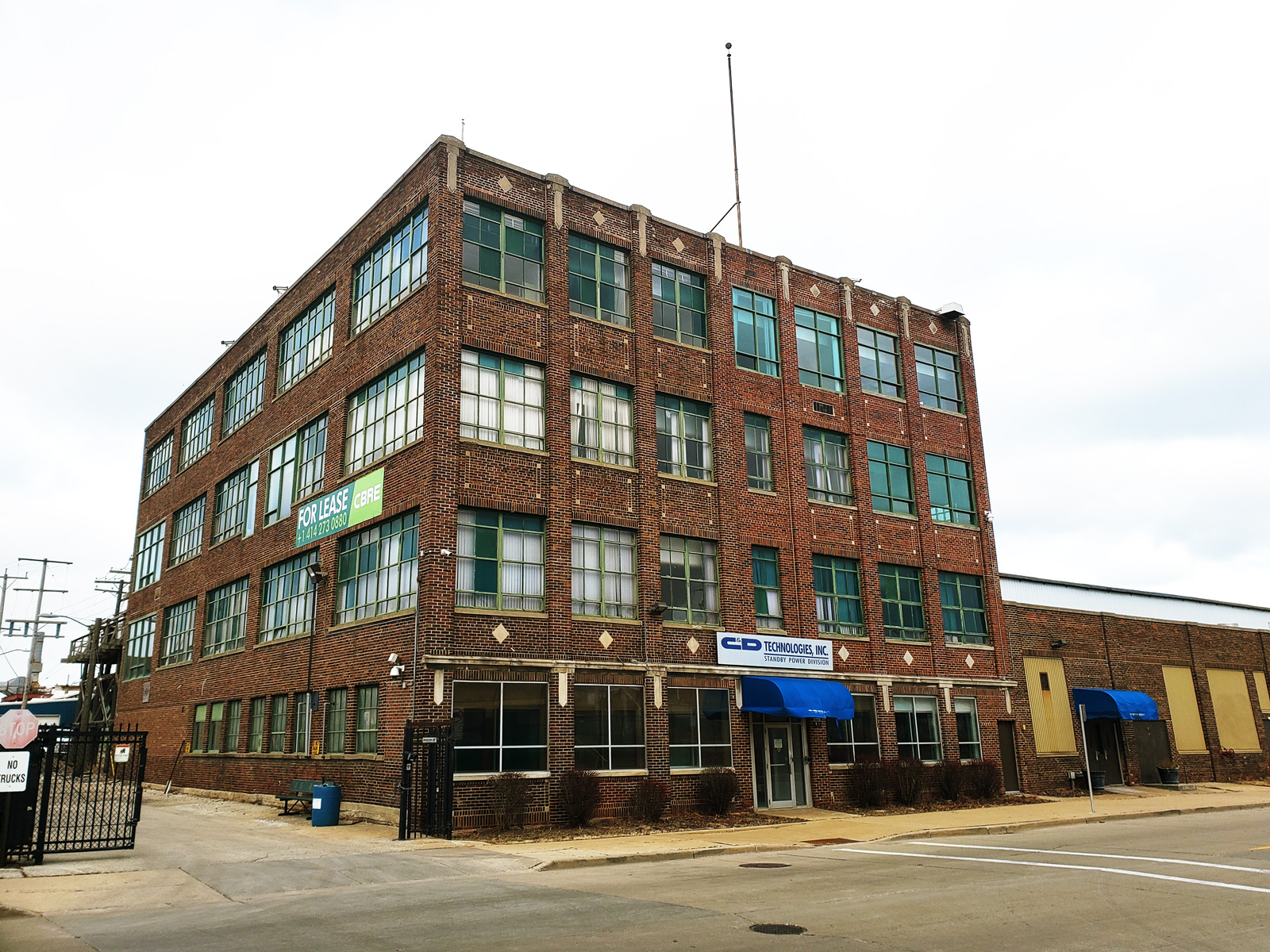 The main building at 900 E Keefe Ave. is a classic example of 1920's industrial red brick architecture.