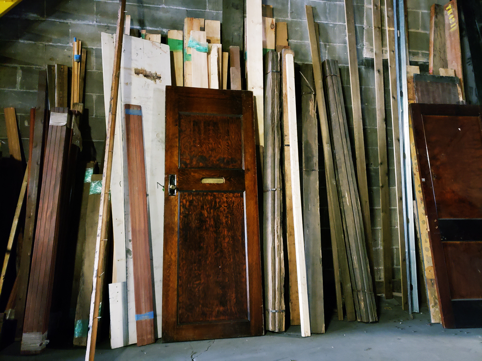 Reclaimed materials are stored against the wall.