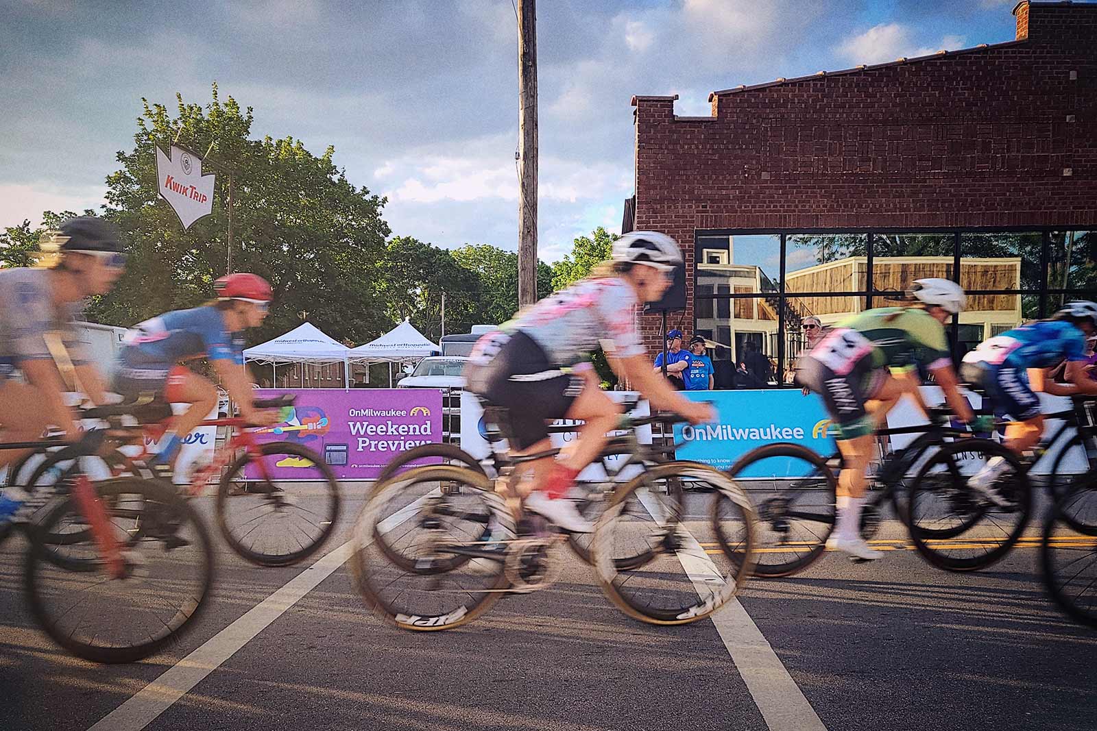 A group of racers blur past the camera at the Tour of America's Dairyland in 2022