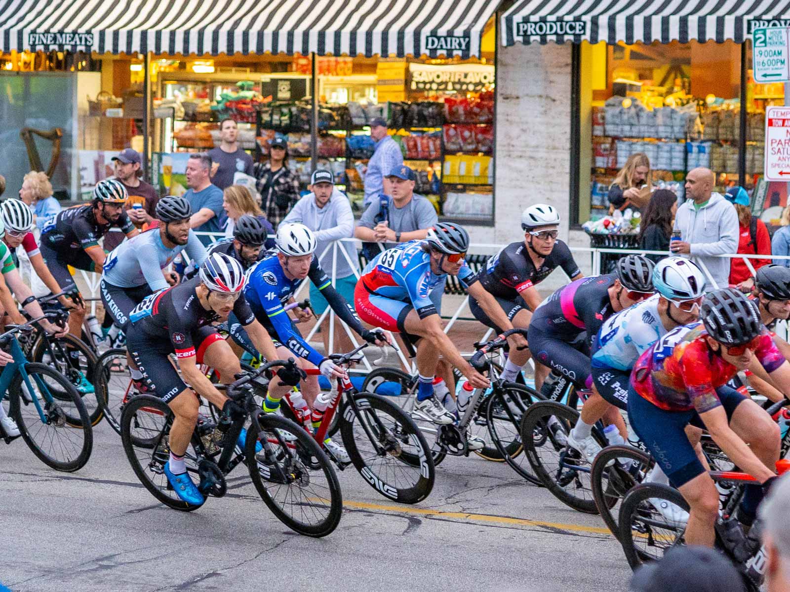 A large group of men strung out across the street during a crit race.