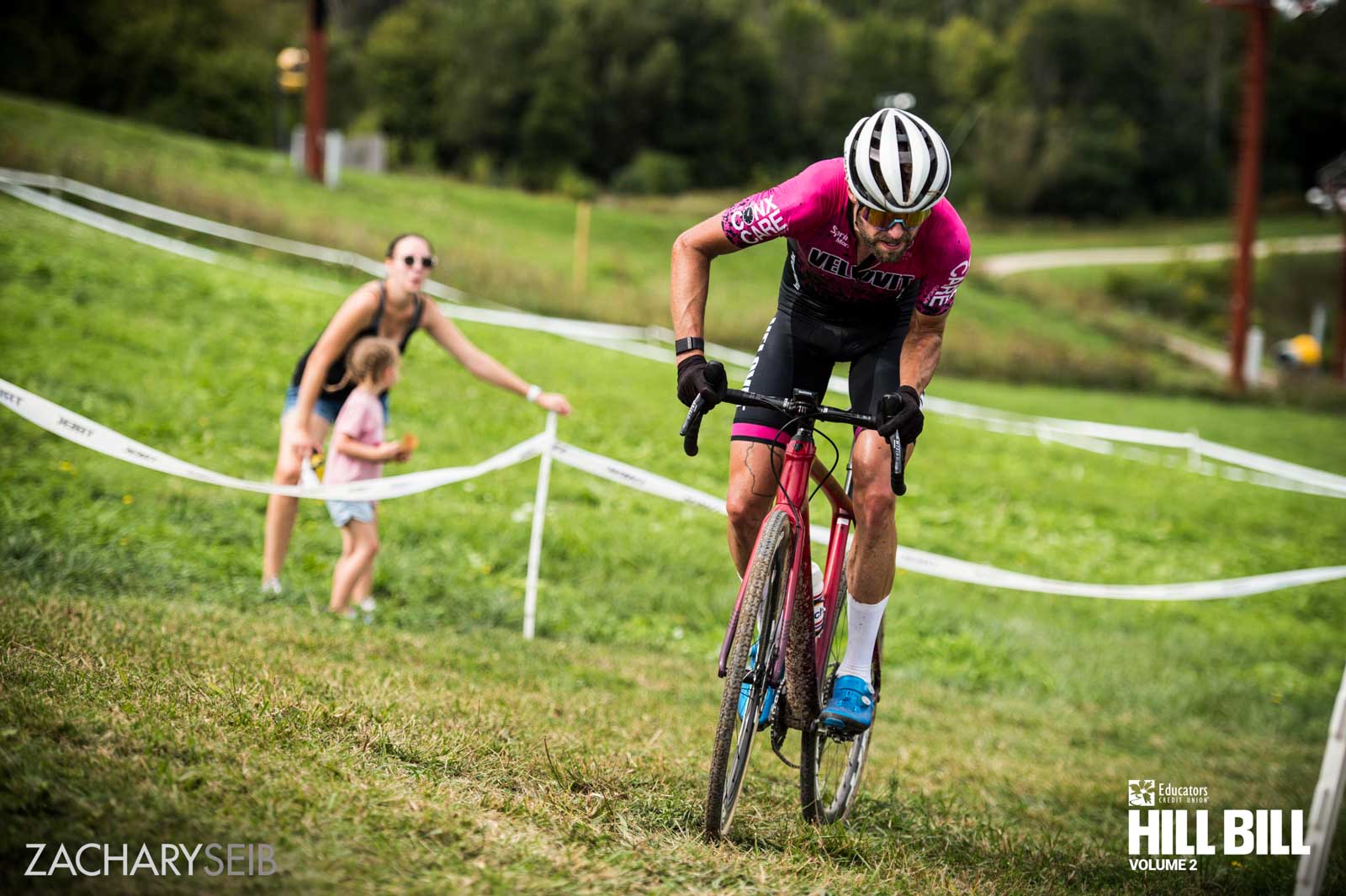 A cyclocross racer aggressively corners in front of fans.