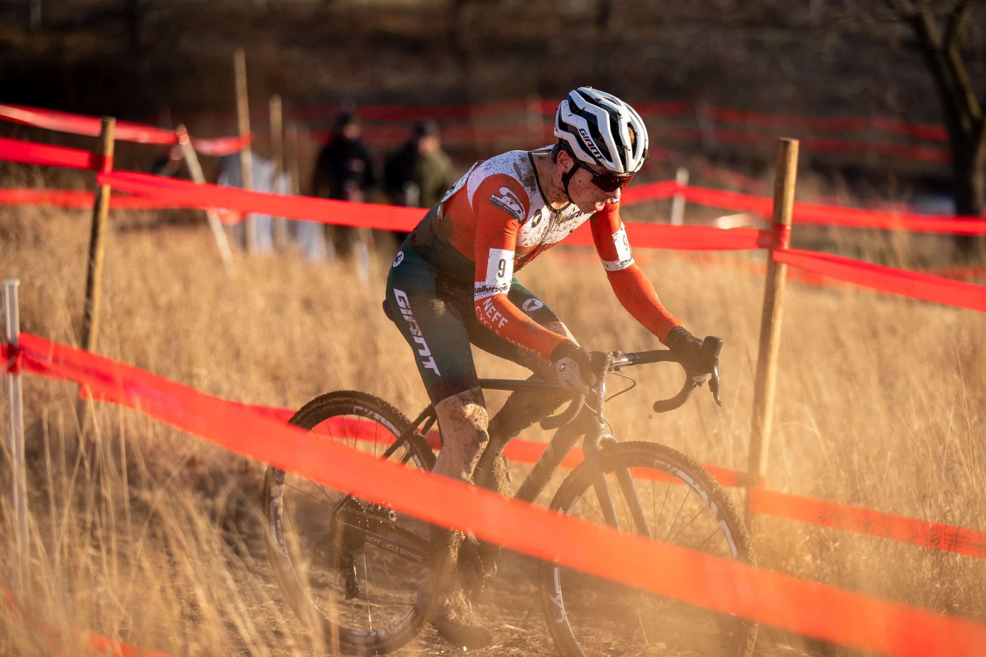 Caleb Swartz racing cyclocross through tall grass.