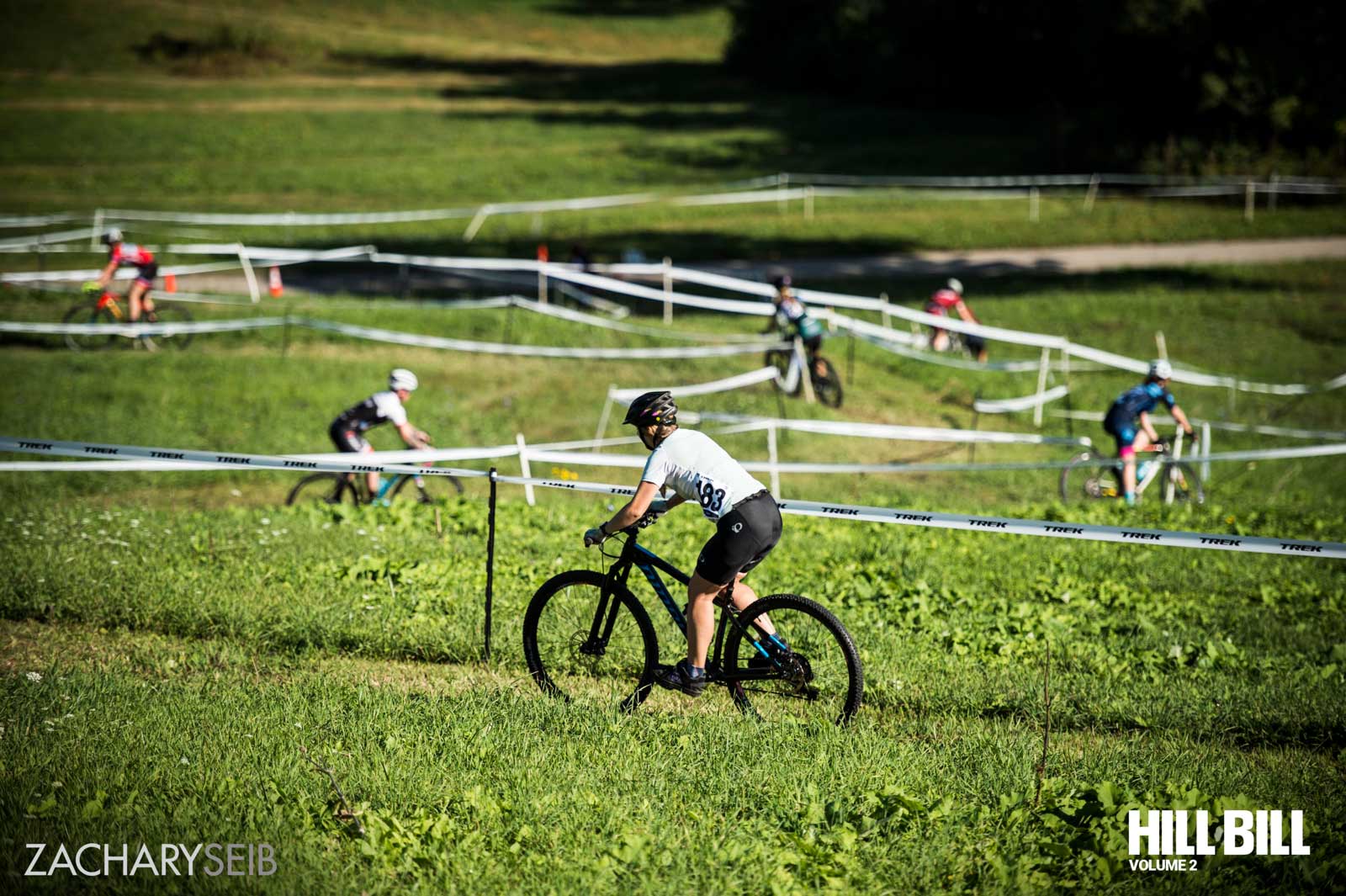 Cyclocross racers zig-zagging down an off-camber descent.