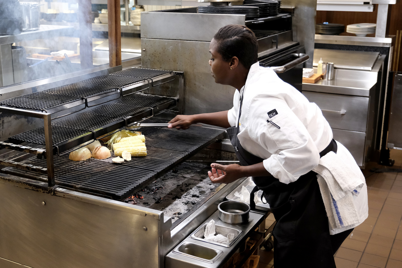 Michelle cooking on woodfired grill at Lupi & Iris