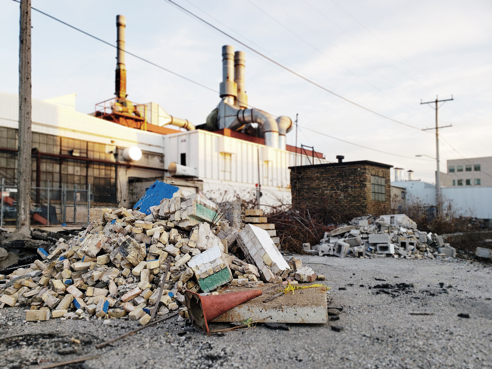 A pile of rubble from the repurposing sits in the driveway.