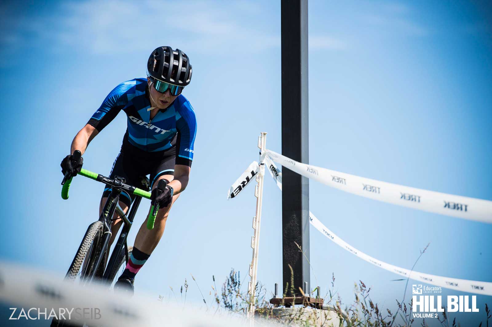 A cyclocross racer zipping around a pole.