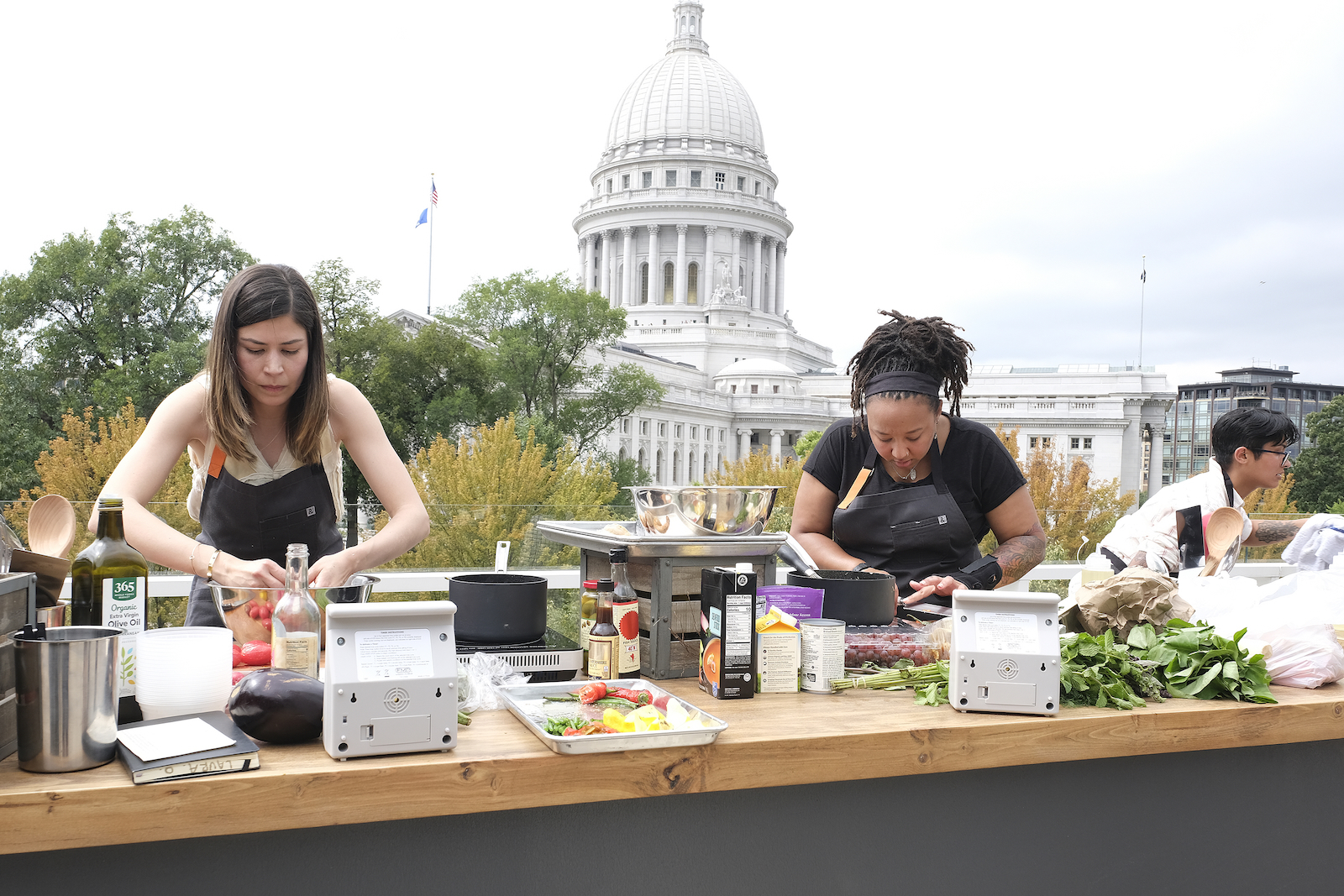 Chefs cooking on rooftop with Capitol in background