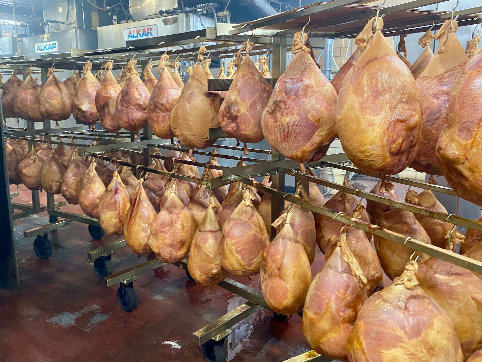 Hanging whole smoked hams.