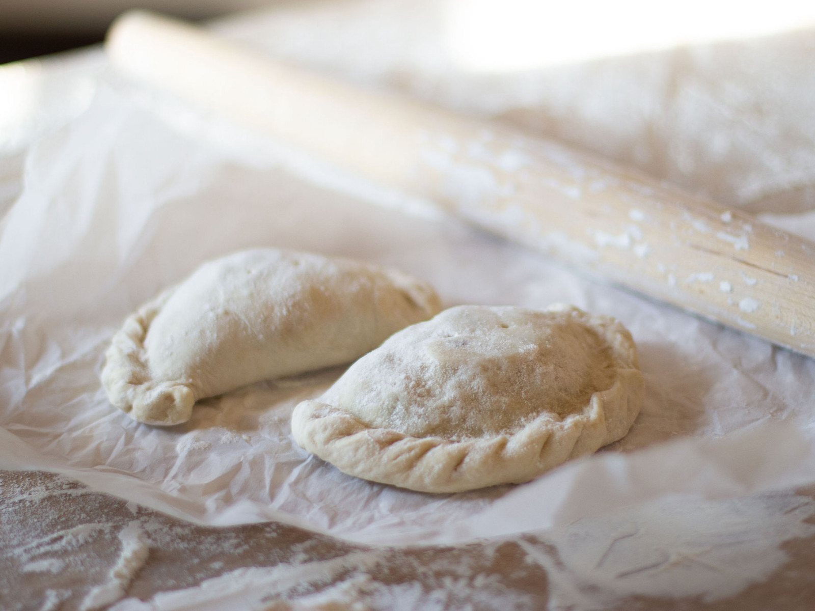 Calzones in flour with rolling pin