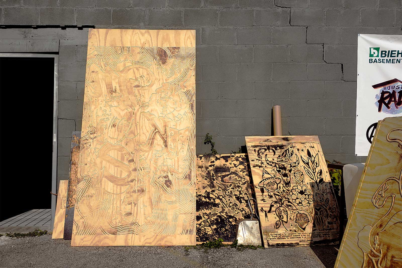 A pile of door-sized wood block prints await ink application.