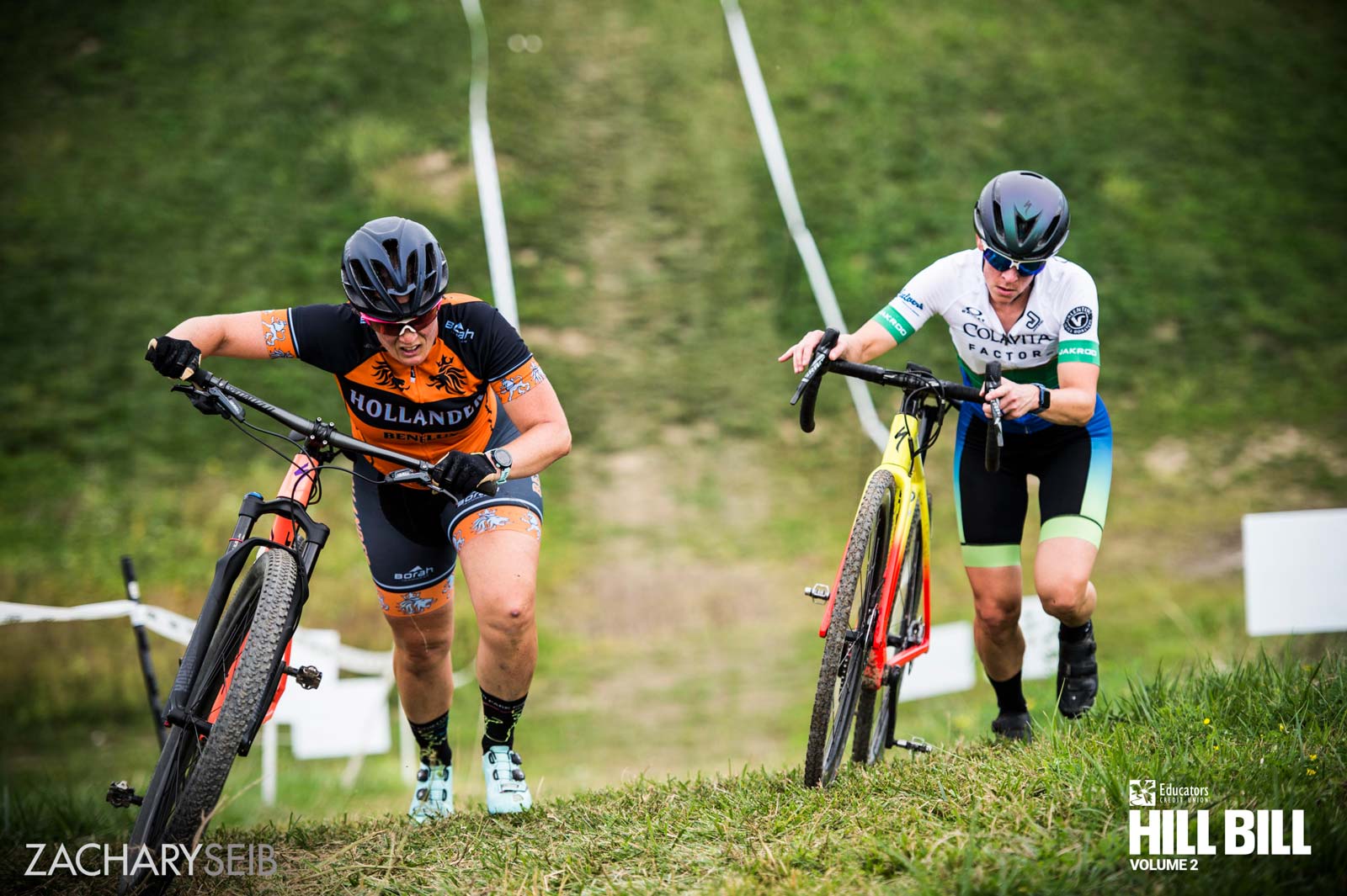 Looking down on two cyclocross racers pushing bikes up a steep hill.