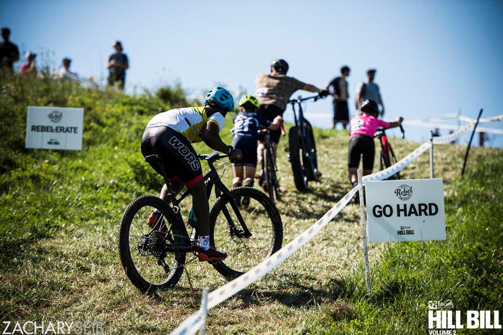 Cyclocross racers struggling up a run-up.