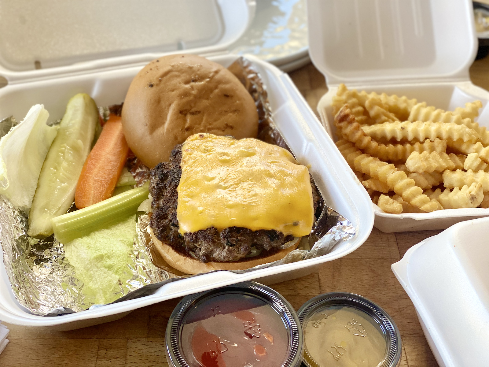 Alioto's cheeseburger and fries in to-go packaging