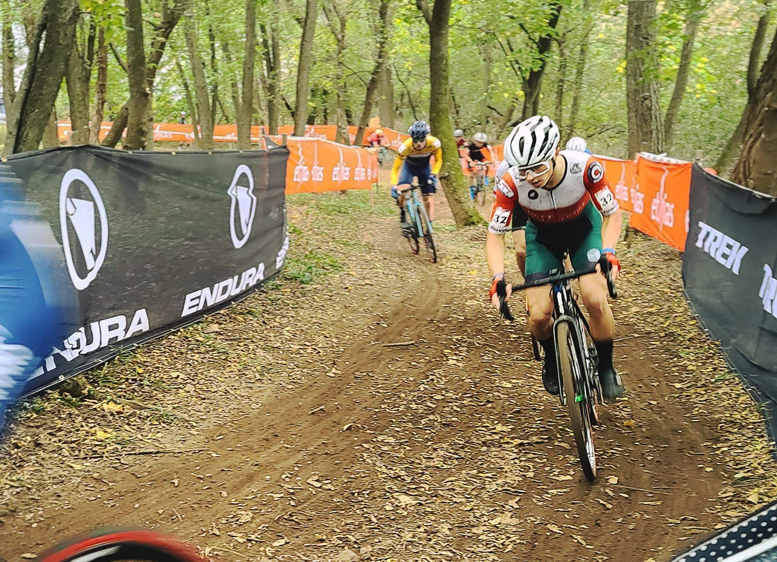 Caleb Swartz in the middle of a cyclocross race field, pursued by Gosse van der Meer