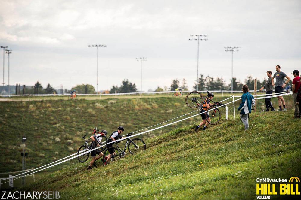 Three cyclocross racers run up a steep run-up.