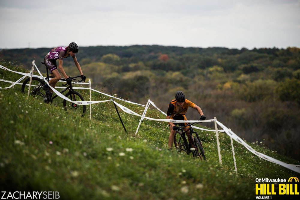 Two cyclocross racers chase each other on an off camber switchback overlooking a beautiful valley.