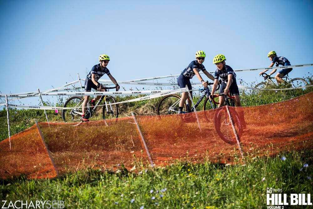 Youth cyclocross racers turn around a switchback.