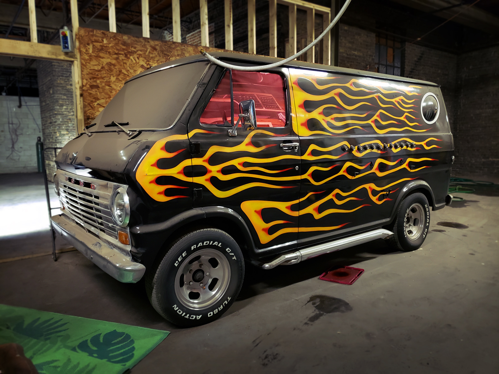 A black van with hot rod flames painted all across its exterior.