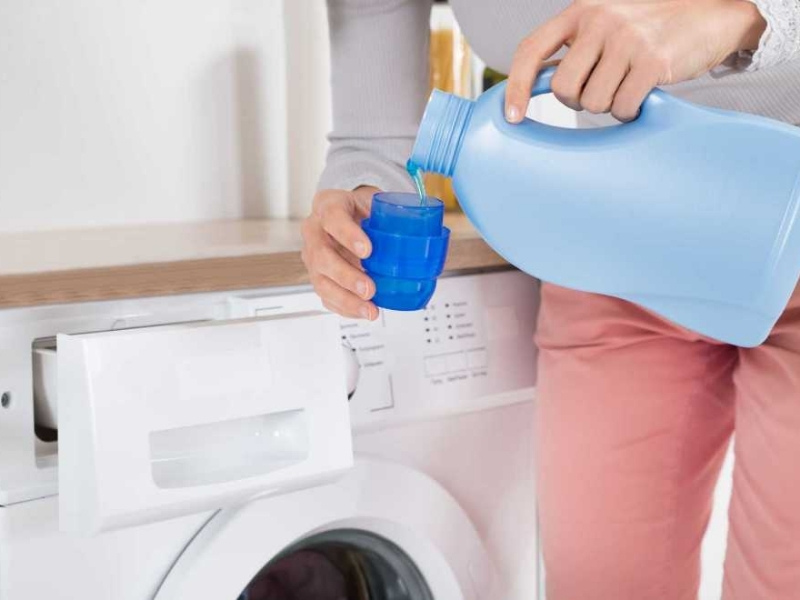 Thêm nước giặt vào máy khi giặt quần jean
