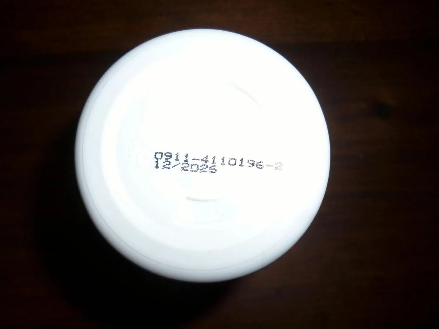 Underside of the PowerBite bottle showing the stamped batch code 0911-4110196-2 and 12/2025 date