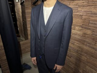 紺に赤いチェックが映えるスリーピーススーツの画像