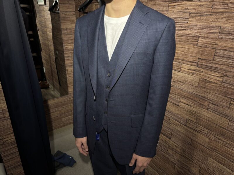 紺に赤いチェックが映えるスリーピーススーツのアイキャッチ画像