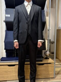 チャコールグレーのスリーピースとダブルカフスのシャツを合わせたフォーマルなスタイルの画像