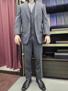 グレーシャツを共にしたグレーストライプ三つ揃えの画像