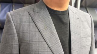 赤の差し色が映えるグレースーツの画像