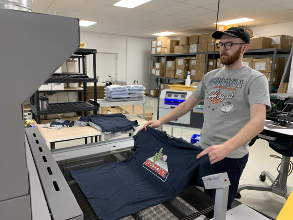 19nine employee folding a shirt for an order