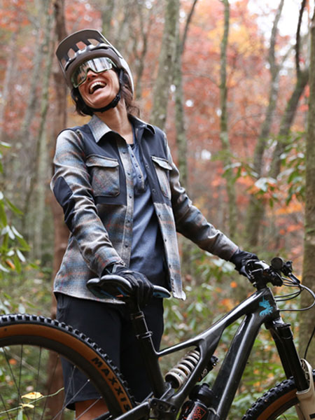 A woman cyclist wearing Kitsbow gear smiling