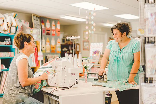 A pair of women doing some quilting and sewing