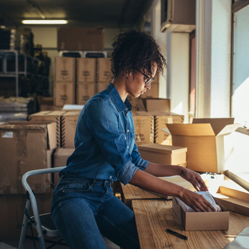 Female packing up a product in her office/warehouse