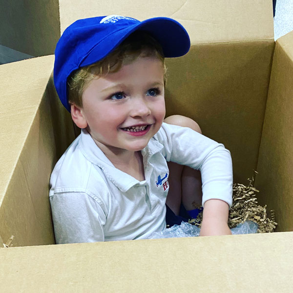 A cute kid in a shipping box.