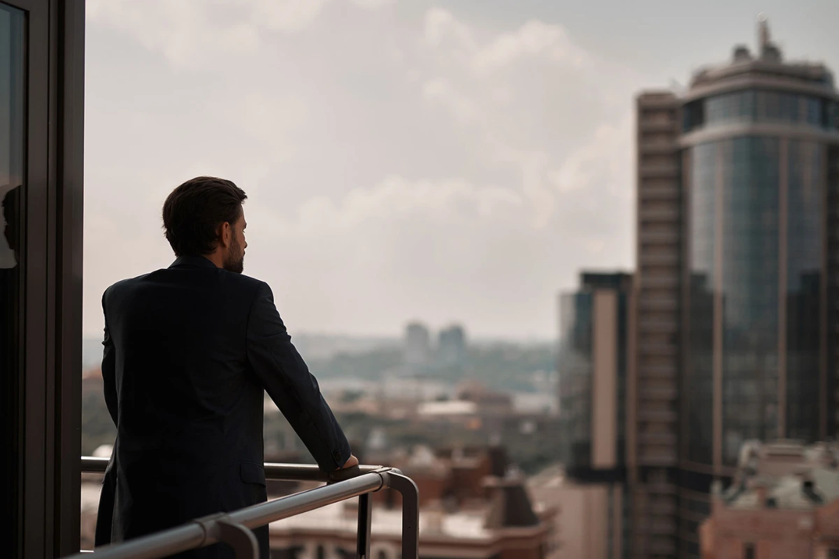 Executive overlooking a city from an office balcony