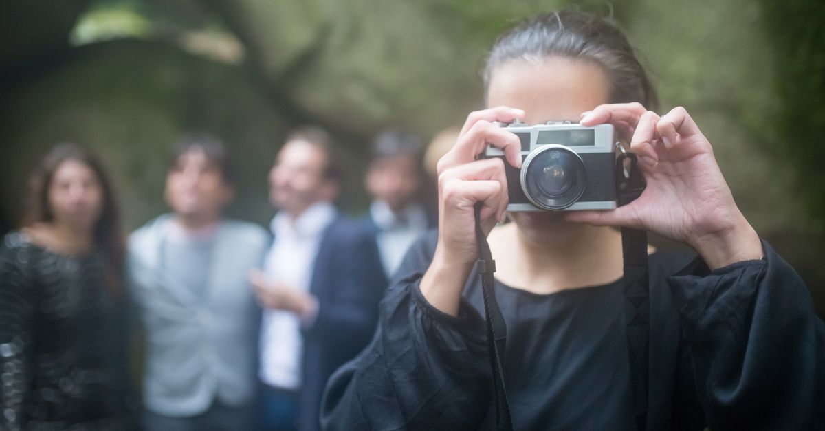Ağaçlık kır düğünü alanında fotoğraf çeken kadın