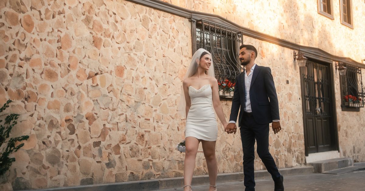 Şehir sokağında yürürken fotoğraflanan gelin ve damat