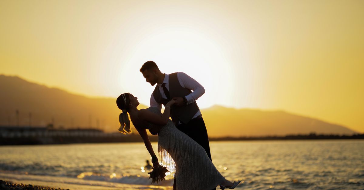 Gün batımında sahilde düğün fotoğrafı çektiren gelin ve damat