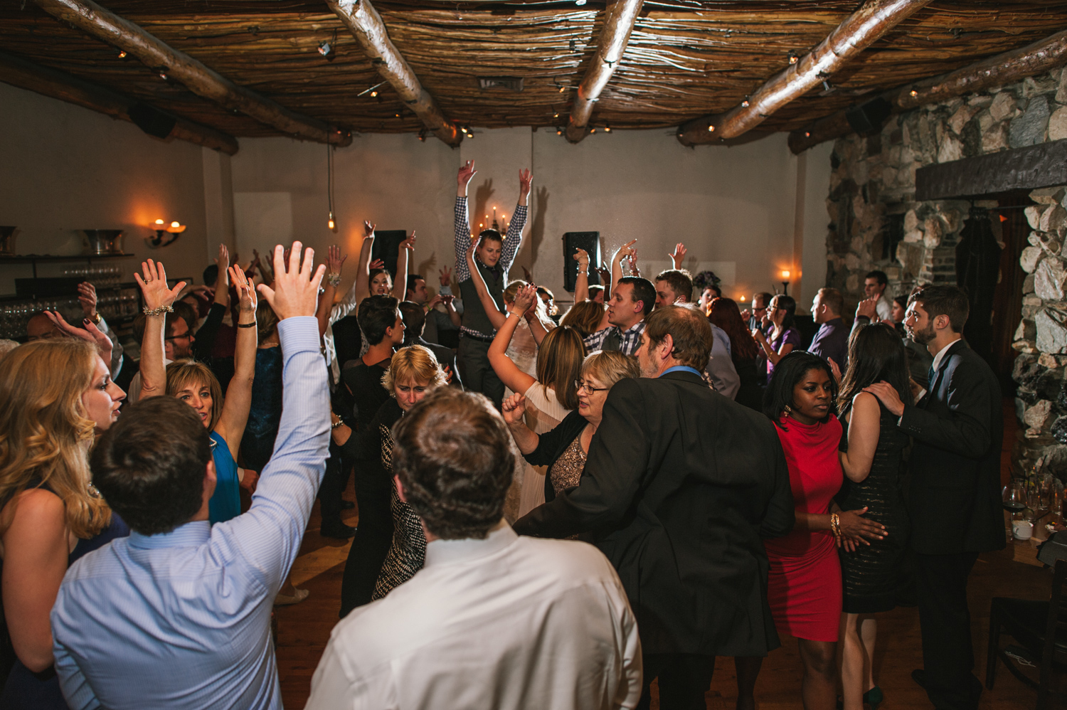 Wedding guests celebrate during wedding reception in dining room at Osteria Via Stato.