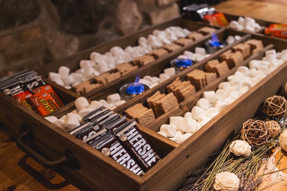 S’mores bar set up with assorted chocolate candy, graham crackers, and marshmallows for private event at Osteria Via Stato.