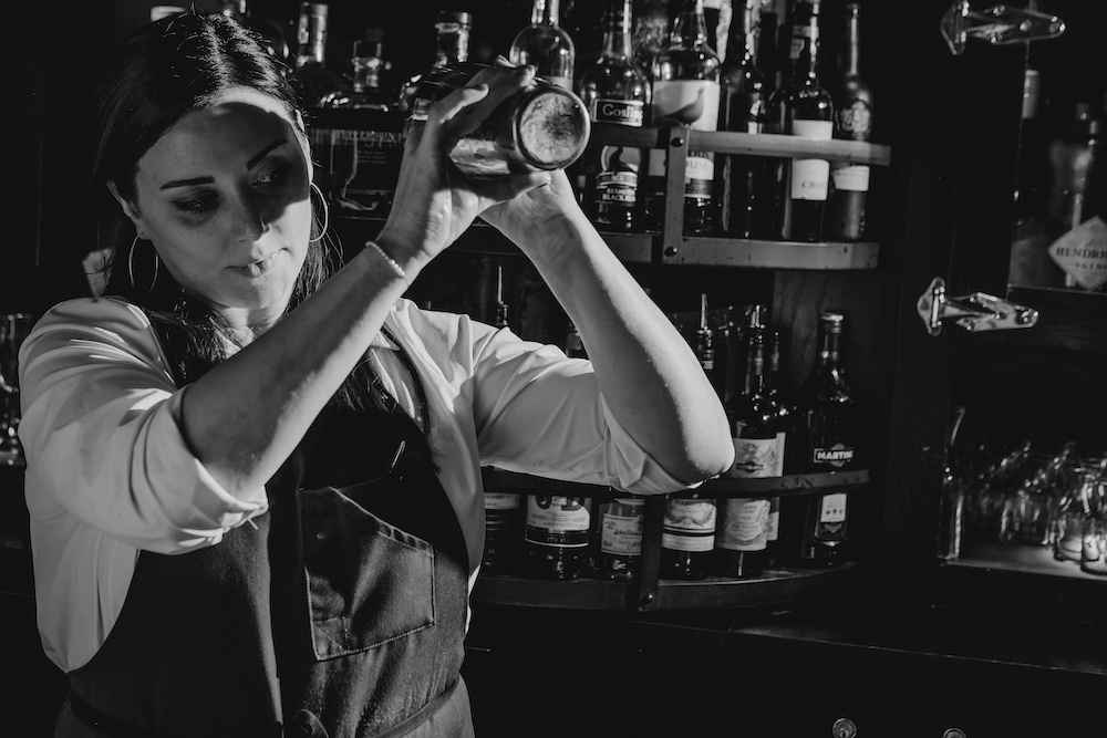 Bartender shakes a cocktail at Osteria Via Stato.