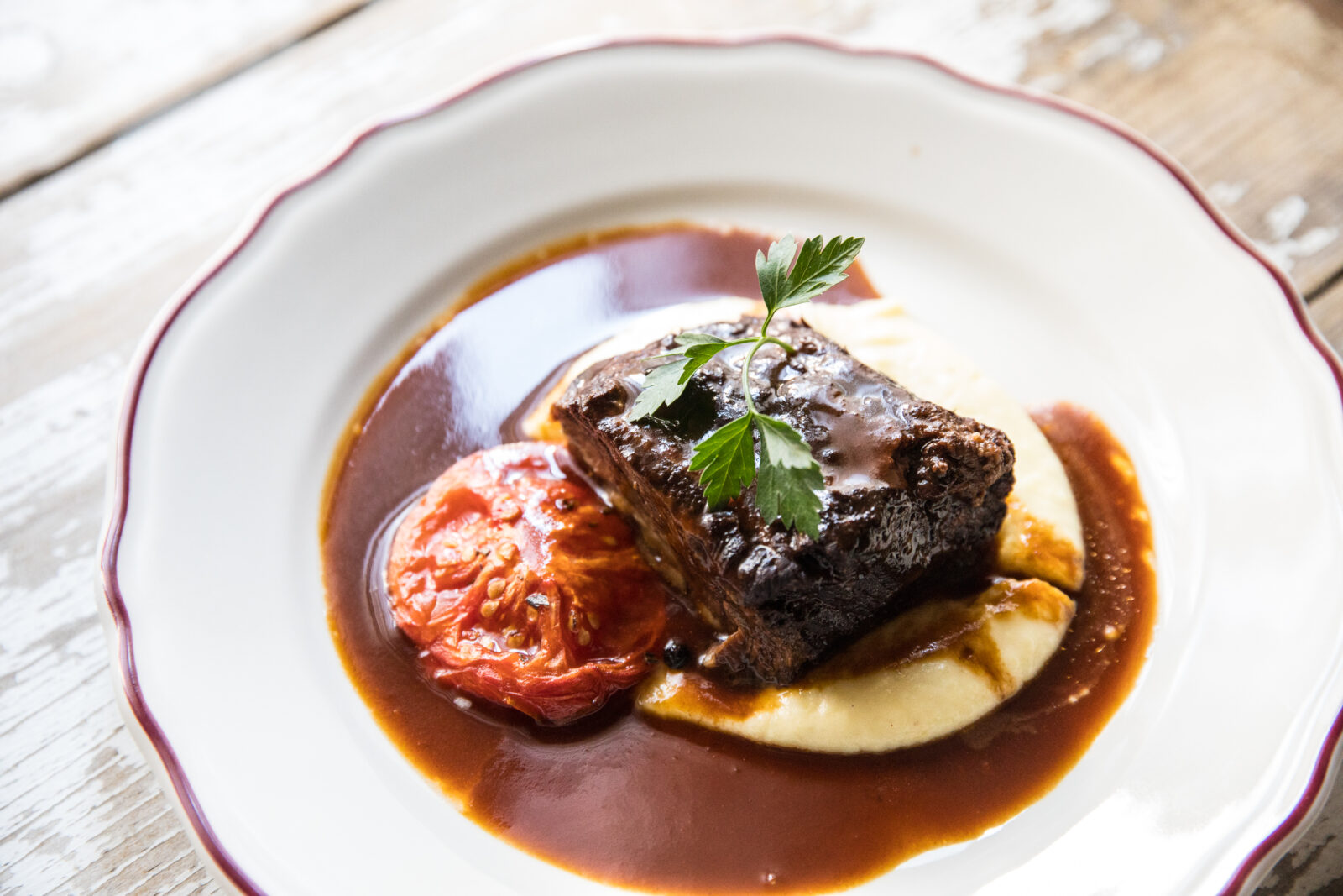 Braised Short Rib plated over whipped potatoes, dressed in a red wine reduction sauce at Osteria Via Stato.