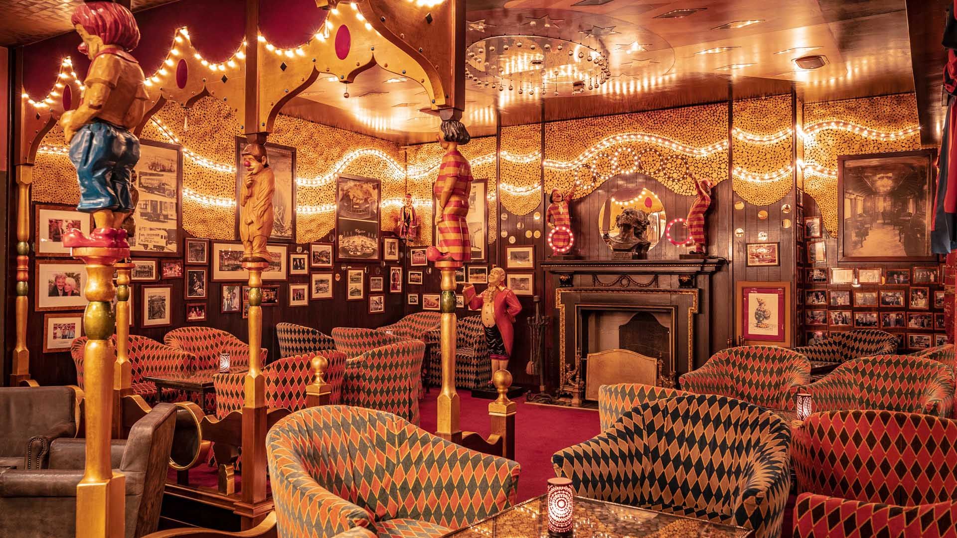 Der Sitzbereich der El Circo Bar ist gemütlich eingerichtet mit bequemen Sesseln, Clownfiguren und nostalgischen Bildern und versprüht somit den Flair eines alten Zirkuswagens.
