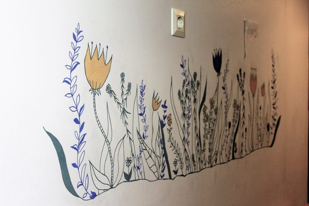 Seinämaalaus, jossa kukkia.