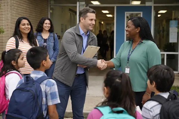 Candid mid-day photo at an Austin ISD elementary campus near the Mueller neighborhood: a city off...