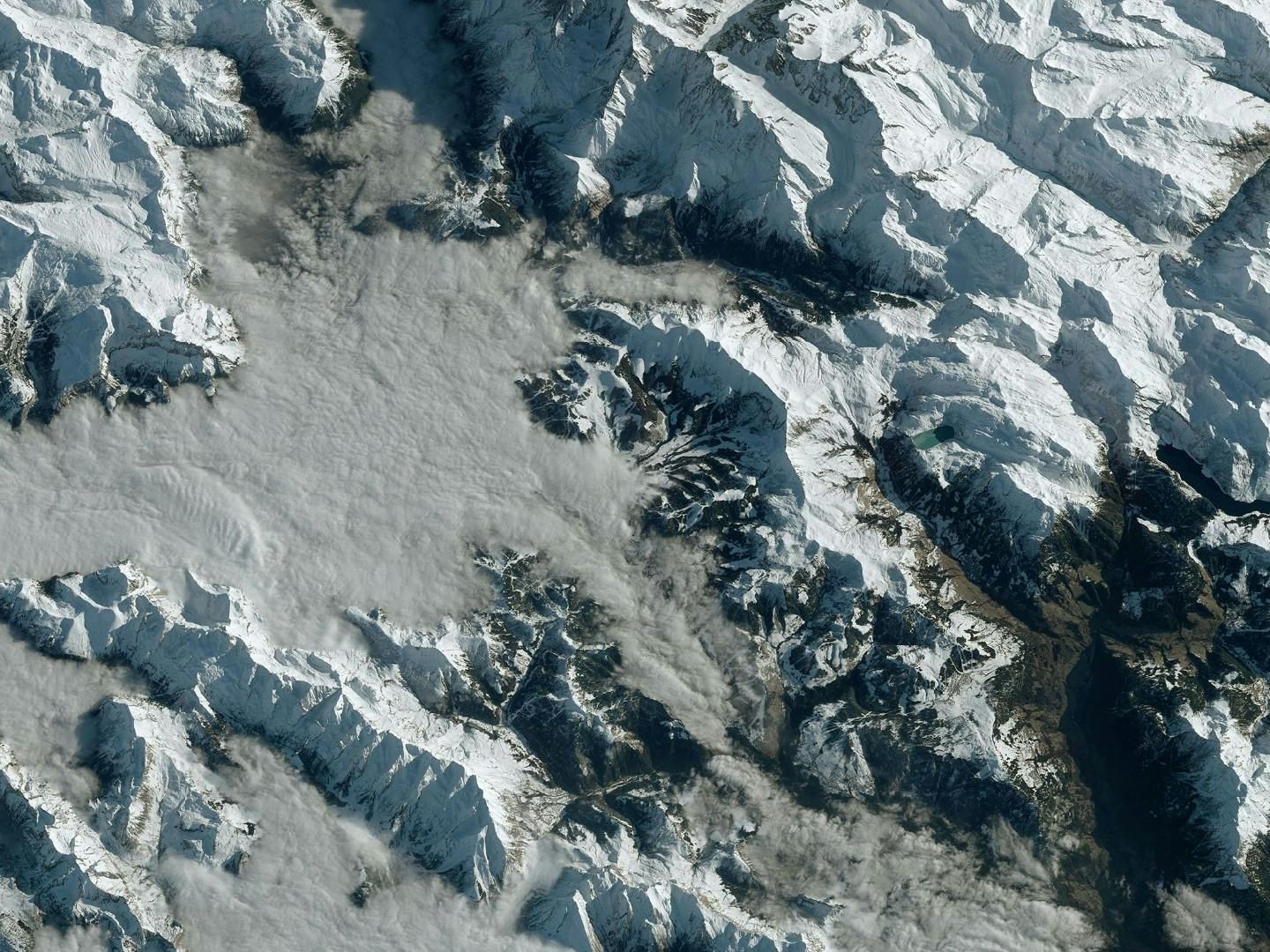 Satellite view of snow-covered mountains and glaciers illustrating climate change impact