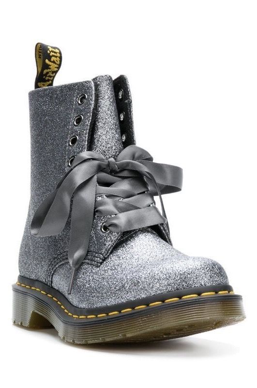 a glittery dr. martens boot with a gray ribbon tied around the laces.
