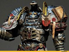 this is a detailed, painted miniature of a space marine from the warhammer 40,000 universe. the figure is intricately painted in shades of grey, gold, red and bone. it stands against a dark background and is lit with artificial lighting.  the perspective makes the miniature appear large and imposing.